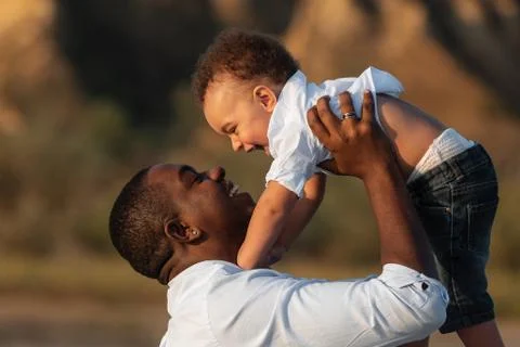 Happy African American father and son having fun outdoors Stock Photos