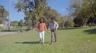 Happy African American Friends Holding Hands And Running On Lawn Stock Footage