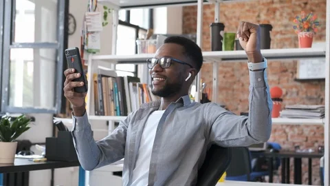 Happy African American man look at smartphone screen overjoyed by great news Stock Footage 116342553