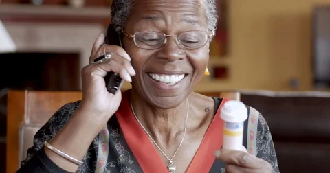Happy African American senior woman calling in her prescription to pharmacy Stock Footage