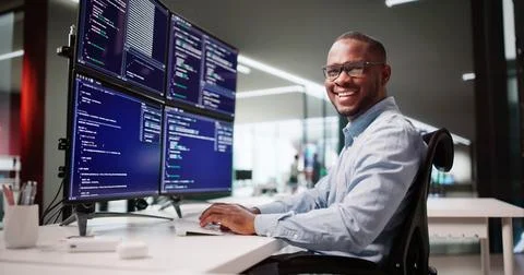Happy African American Web Developer Coding At Office Desk Screen 스톡 사진