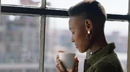 Happy African American Woman Drinking Coffee At Home Enjoying Aroma Looking Out Stock Footage