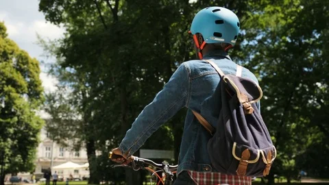 Happy african man in helment cycling in the park than turning to the camera and Stock Footage