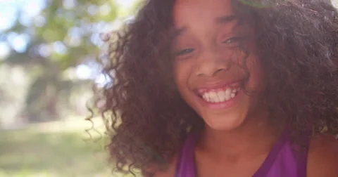 Happy Afro girl laughing playfully in a park Stock Footage