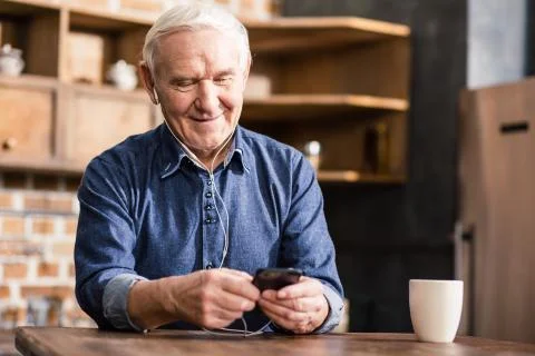 Happy aged man using his phone Stock Photos