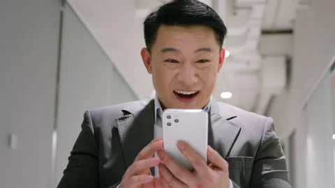 Happy amazed 40s middle-aged man looking at mobile phone in office male winner Stock Footage 244489673