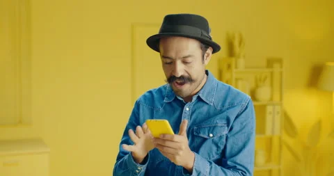 Happy amazed man with mustache using a mobile phone looking and scrolling the Stock Footage 171446845