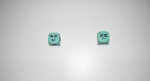 Happy and Angry Faces on Mint Green Dice Stock Photos