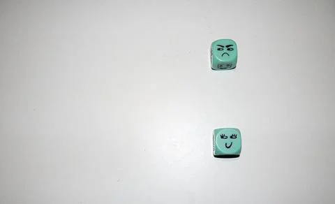 Happy and Angry Faces on Mint Green Dice Stock Photos