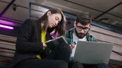 Happy and charismatic two multiethnic students order online something using a Video stock 133404753