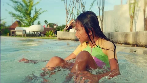 Happy and cute 7 years old Asian Indonesian girl having fun at swimming pool Stock Footage 132675673