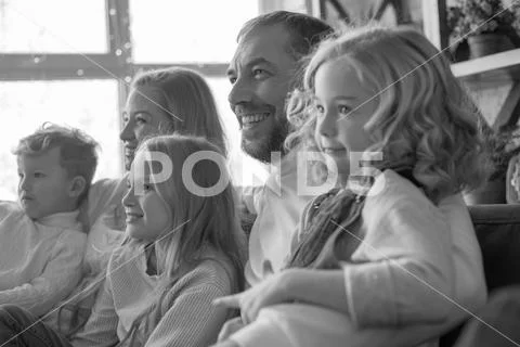 Happy and friendly family hugging on the couch. Stock Photos