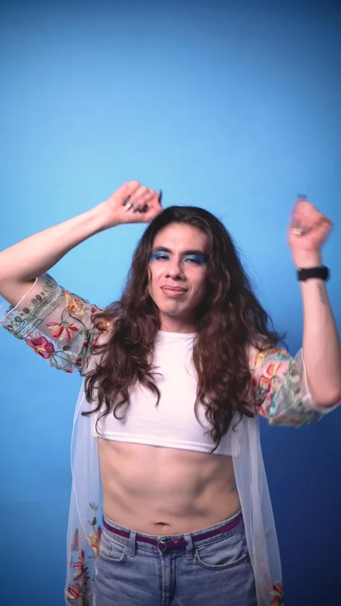 Happy and radiant non-binary stylish person with very long hair on blue Stock Footage 309138637