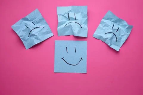 Happy and sad face notes on pink background Stock Photos