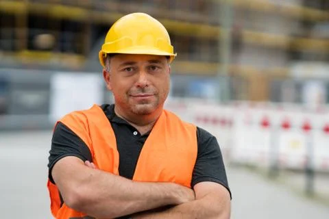 Happy and satisfied engineer posing on construction site  with crossed arms 스톡 사진