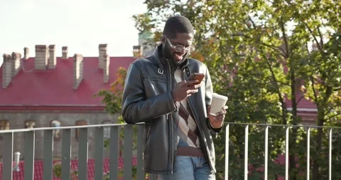 Happy and Satisfied Man Looking at Smartphone’s Screen and Laughing. Reading Video stock 133000331