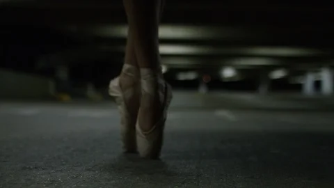 Happy and smiling ballet dancer on pointe in a car park at night Vidéo 85618202