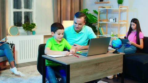 Happy and smiling large dad and his son doing the school homework online using Video stock 146186724