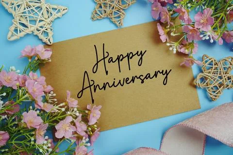 Happy Anniversary text on paper card with fabric ribbon and rattan star dec.. Foto stock