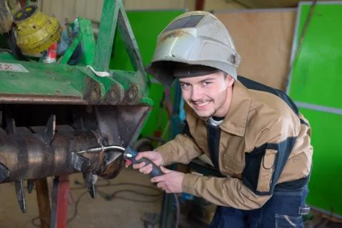 Happy apprentice welder at work in the plant Stock Photos