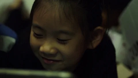 Happy asian child looking screen on tablet computer at home Stock Footage