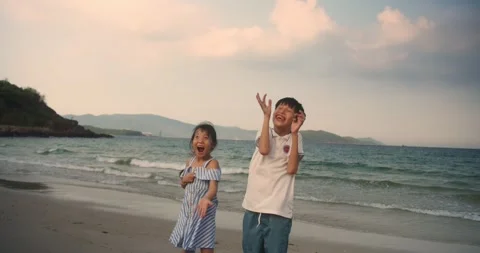 Happy Asian children throwing shells by the sea happy childhood, siblings and Stock-Footage 315300433