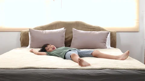 Happy asian elementary school boy jumping on bed and have fun dancing, kid .. Stock Footage 249493028