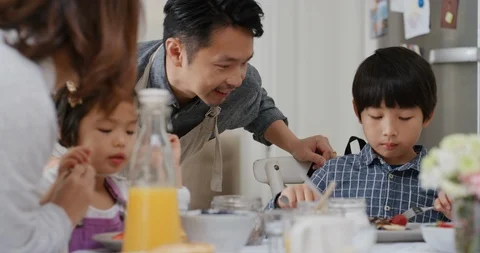 Happy asian family eating pancakes for breakfast children enjoying healthy Stock Footage
