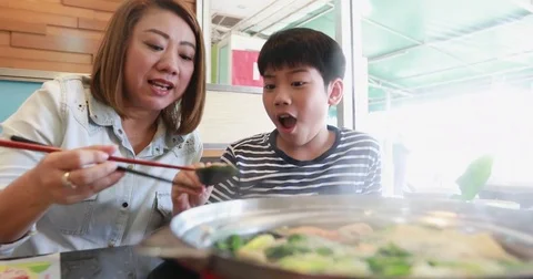 Happy asian family mother and son enjoy eating Stock Footage