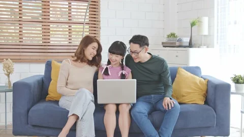 Happy Asian family using computer laptop together on sofa at home living room Stock Footage 152253399