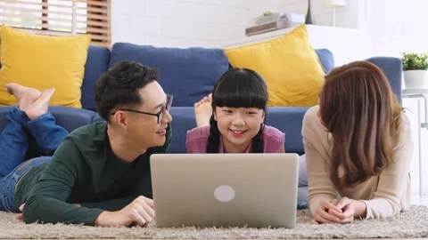 Happy Asian family using computer laptop together on sofa at home living room Stock Footage 230865920