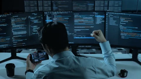 Happy Asian Man Looking At Code On Mobile Phone While Write Code With Multiple Stock Footage 255844643