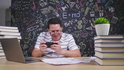 Happy Asian man playing game on smartphone in working room at home Video stock 172057341