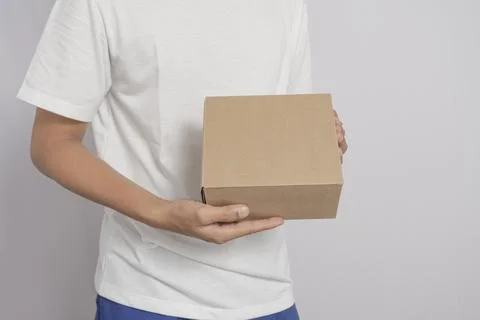 Happy Asian man smiling while holding a package box. Concept of sending pac.. Stock Photos