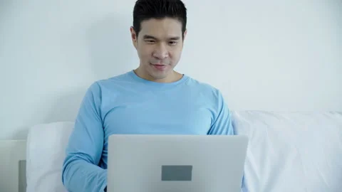 Happy Asian man using notebook Or laptop to work in room at home. Talk to people Video stock 140447951