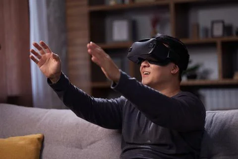 Happy Asian man using VR and playing video games at home. Joyful man using Stock Photos