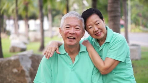 Happy Asian senior couple smiling after exercise in the park Stock Footage