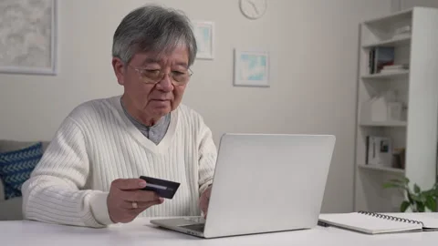 Happy Asian senior man using Laptop and credit card payment shopping online. Video stock 221313744