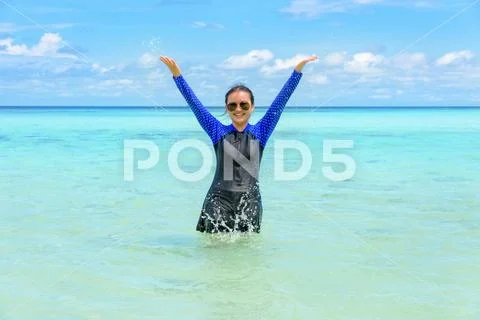 Happy asian teen girl play splashing water in the sea Stock Photos