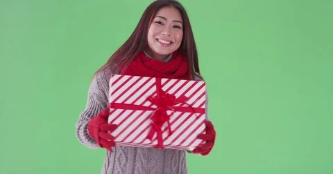 Happy asian woman holding presents in the snow on green screen Stock Footage