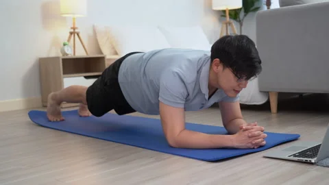 Happy asian young man doing exercise and watching tutorial on laptop with m.. Stock Footage 252816136