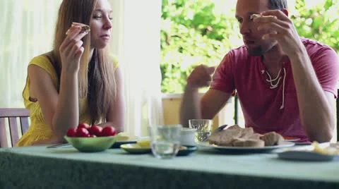 Happy, attractive couple eating breakfast together on the terrace Stock Footage