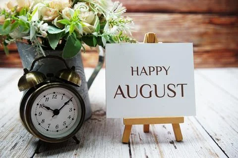 Happy August text message written on paper card with wooden easel and alarm.. Stock Photos