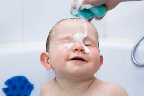 Happy baby boy bathing Stock Photos