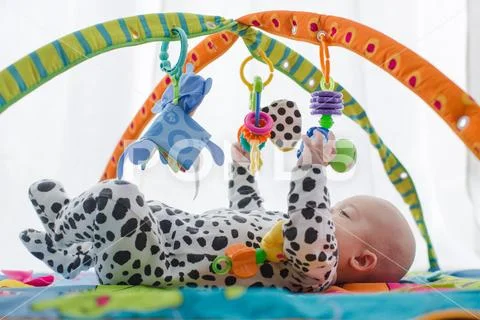 Happy baby boy smiling on playmat Stock Photos