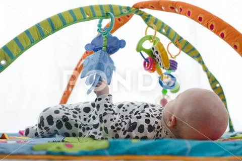 Happy baby boy smiling on playmat Stock Photos