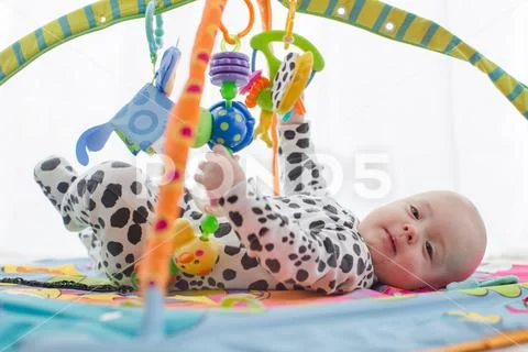 Happy baby boy smiling on playmat Stock Photos