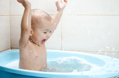 Happy baby boy taking a bath Stock Photos