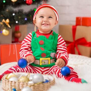 Happy baby elf with Christmas decorations laughing Stock Photos