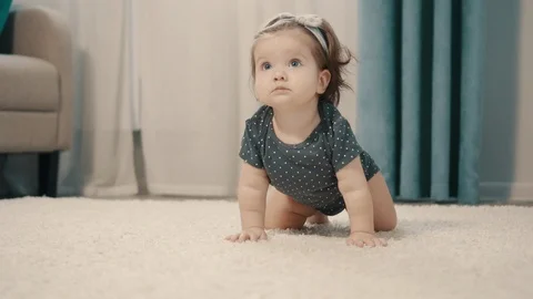 Happy baby girl crawling on floor, close up Stock Footage